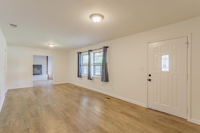 foyer entrance featuring visible vents, baseboards, and light wood-type flooring