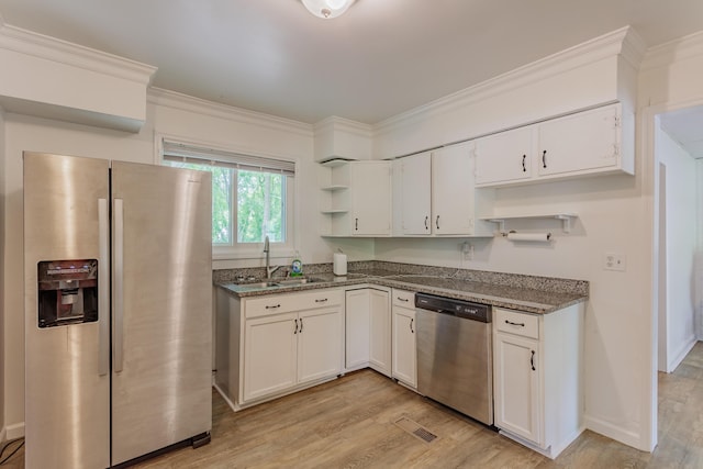 kitchen with open shelves, appliances with stainless steel finishes, a sink, light wood-style floors, and white cabinetry
