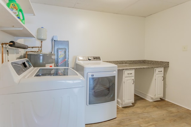 washroom featuring baseboards, washer and clothes dryer, water heater, and light wood-type flooring