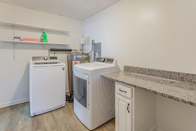 laundry area with laundry area, washer and clothes dryer, and light wood-style flooring