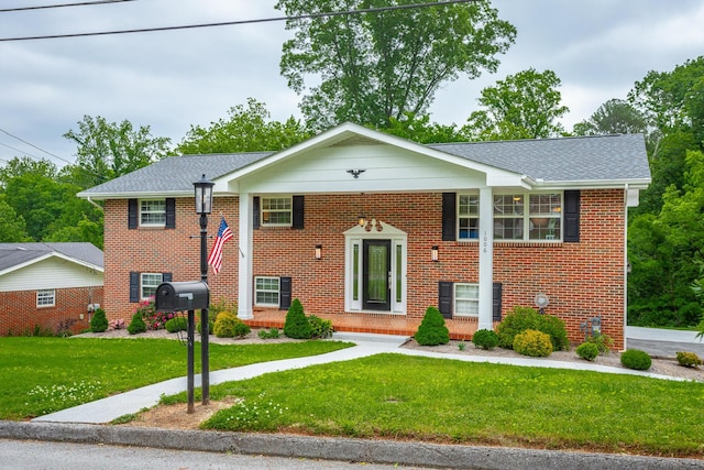 split foyer home featuring brick siding and a front yard