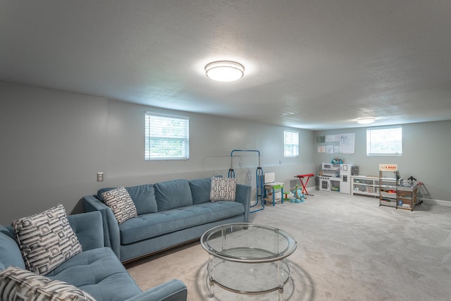 living area with carpet floors, a textured ceiling, and baseboards