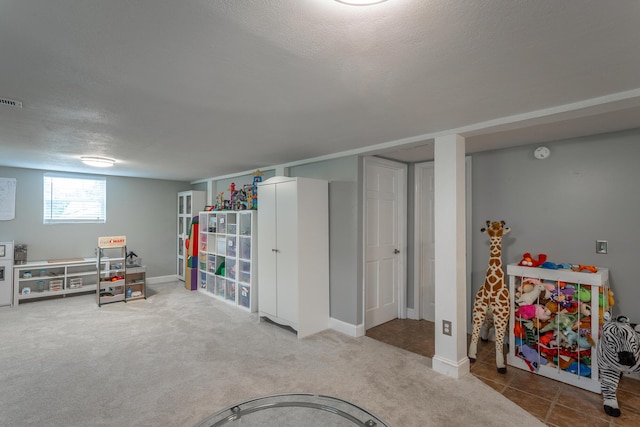 rec room featuring a textured ceiling, baseboards, and carpet
