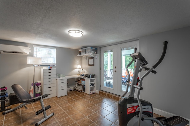 exercise area with french doors, a textured ceiling, tile patterned flooring, baseboards, and an AC wall unit