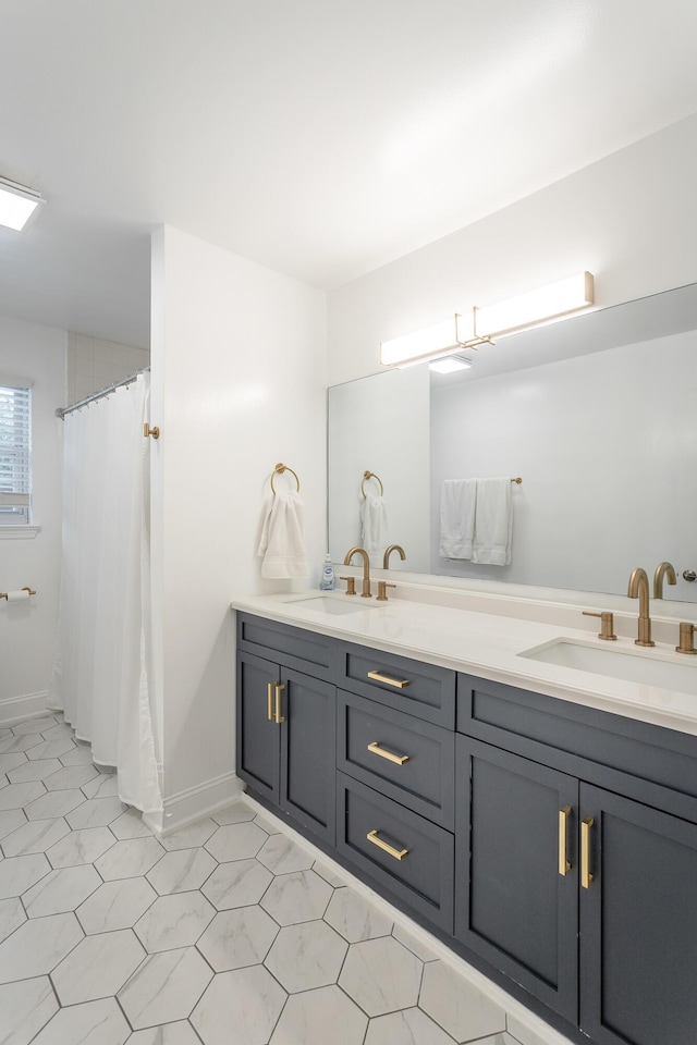 bathroom with a sink, baseboards, curtained shower, and double vanity