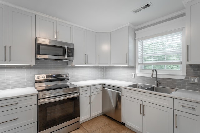 kitchen with light countertops, stainless steel appliances, visible vents, and a sink