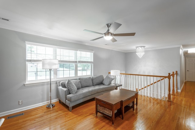 living area with baseboards, a wealth of natural light, wood finished floors, and visible vents