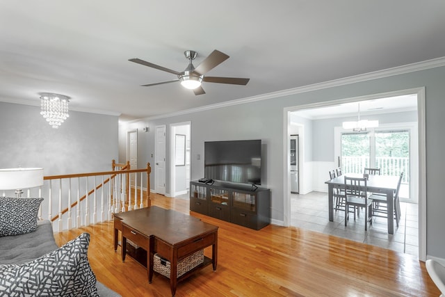 living room featuring ornamental molding, wood finished floors, and ceiling fan with notable chandelier