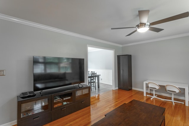 living room with baseboards, ornamental molding, light wood finished floors, and a ceiling fan
