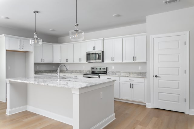 kitchen featuring stainless steel appliances, a sink, light wood-type flooring, and white cabinets