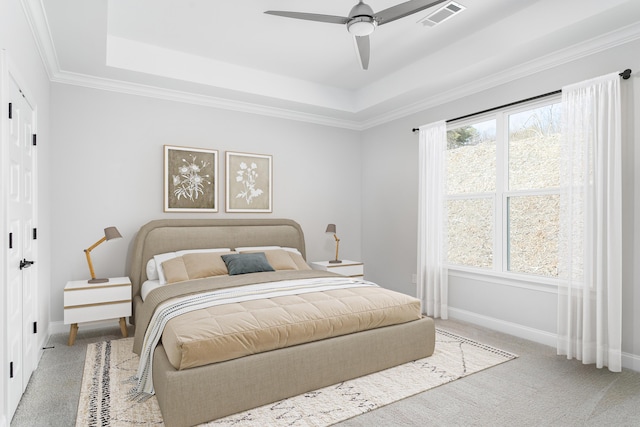 bedroom featuring carpet flooring, a tray ceiling, baseboards, and ornamental molding