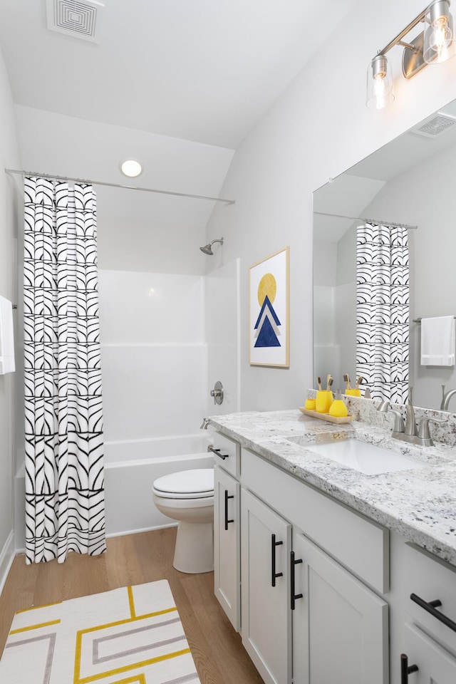 full bathroom with wood finished floors, toilet, shower / bath combo, and vanity
