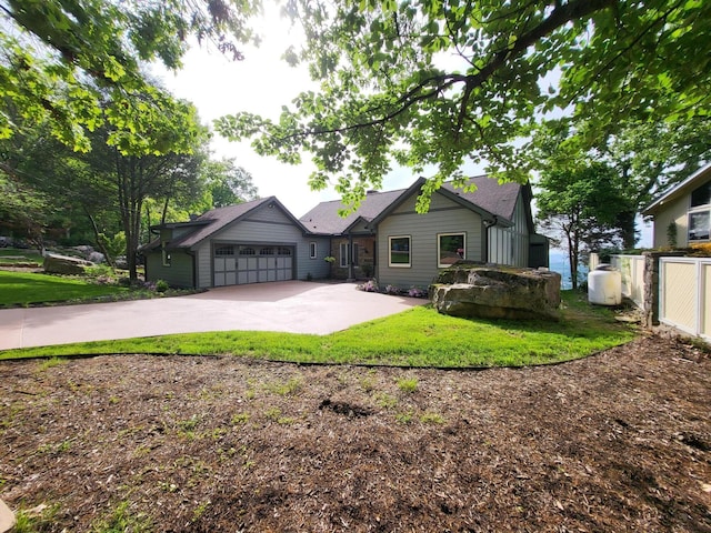 craftsman inspired home with a garage, fence, concrete driveway, and a front lawn
