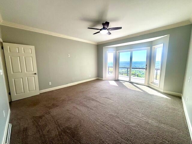 spare room featuring carpet flooring, a ceiling fan, baseboards, and crown molding