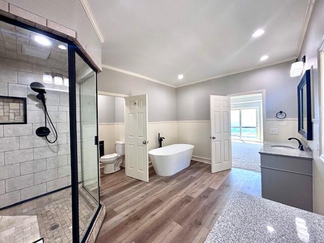 full bath with ornamental molding, a shower stall, and wood finished floors