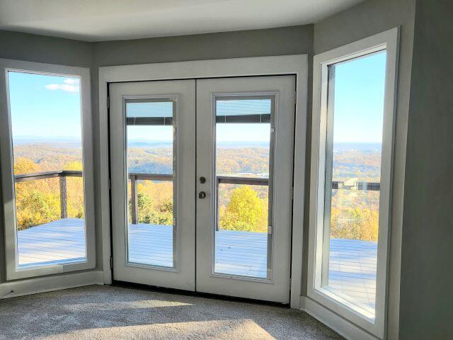 doorway to outside featuring french doors and carpet flooring