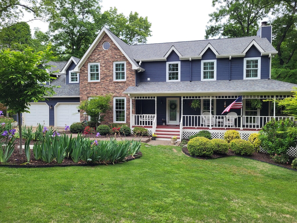 9619 Mountain Shadows Dr, Chattanooga, TN 37421 - view of front of house with an attached garage, a front yard, a chimney, a shingled roof, and a porch