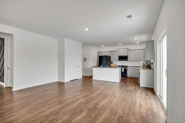 kitchen with gray cabinets, dark wood-style flooring, visible vents, appliances with stainless steel finishes, and a center island
