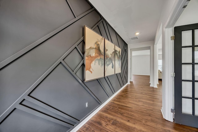 corridor with plenty of natural light, wood finished floors, and visible vents