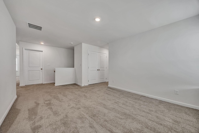 carpeted spare room featuring recessed lighting, baseboards, and visible vents