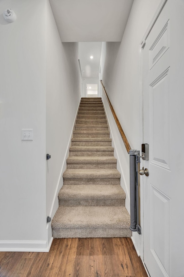 staircase with baseboards, recessed lighting, and wood finished floors