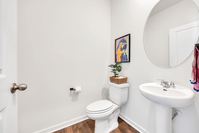 bathroom featuring toilet, baseboards, and wood finished floors