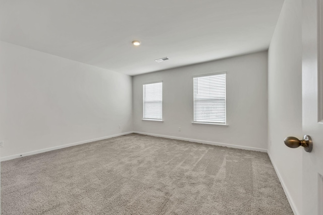 unfurnished room featuring carpet floors, baseboards, and visible vents