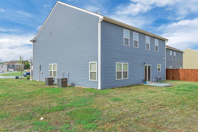 back of property with a yard, fence, central AC unit, and a patio area