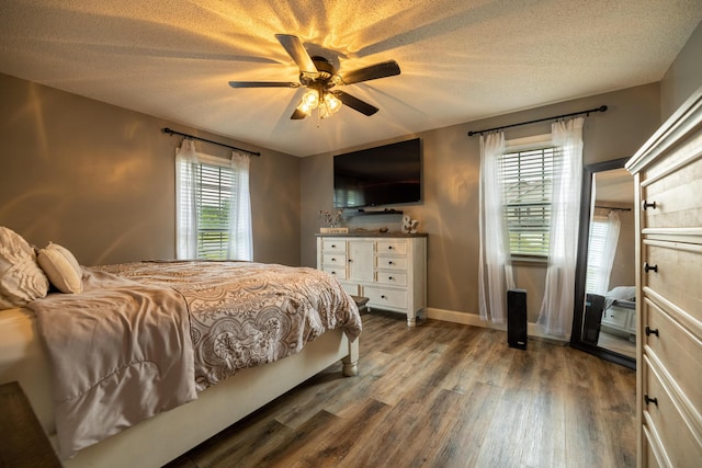 bedroom with baseboards, a textured ceiling, ceiling fan, and wood finished floors