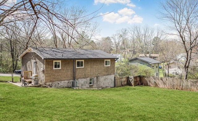 back of property with a lawn, fence, and central air condition unit