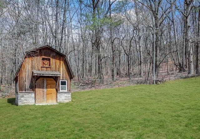 view of barn with a lawn and fence