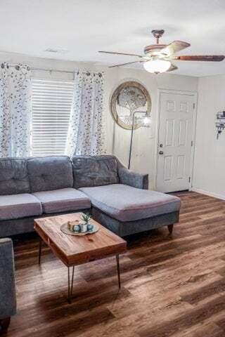 living area with baseboards, ceiling fan, and wood finished floors