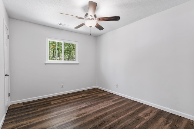 spare room featuring baseboards, a ceiling fan, dark wood finished floors, and visible vents