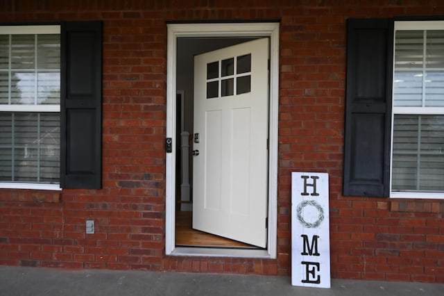 doorway to property with brick siding