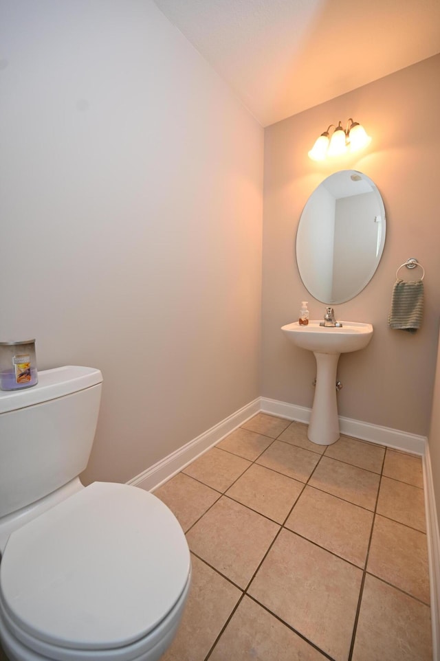 bathroom with tile patterned flooring, baseboards, and toilet