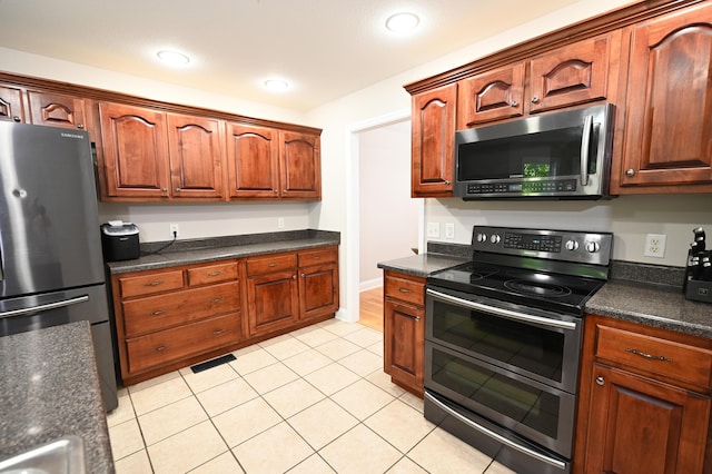 kitchen featuring visible vents, dark countertops, stainless steel appliances, recessed lighting, and light tile patterned flooring