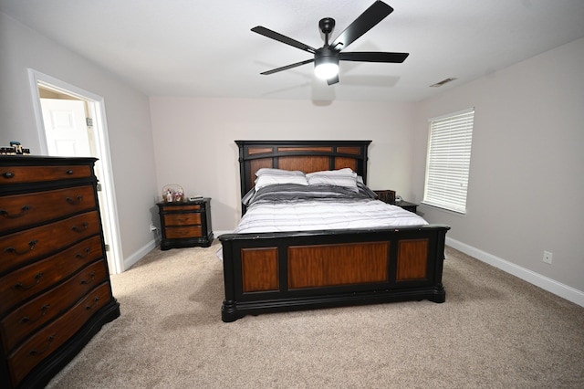 bedroom featuring a ceiling fan, baseboards, visible vents, and light carpet