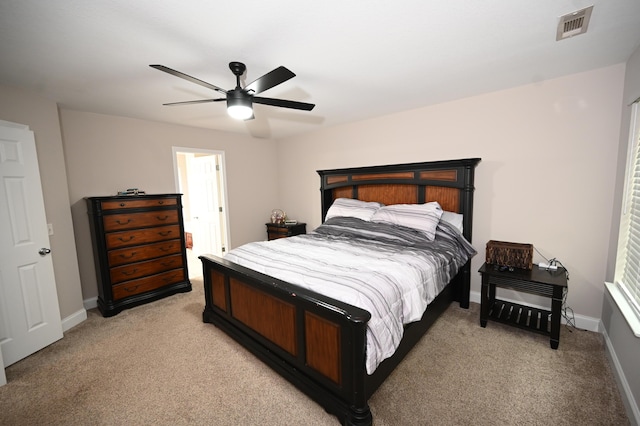 bedroom with baseboards, visible vents, a ceiling fan, and light colored carpet