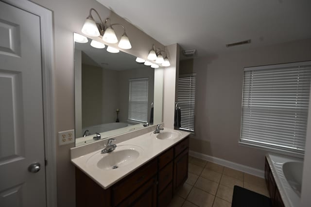 full bath with a sink, baseboards, tile patterned flooring, and a tub