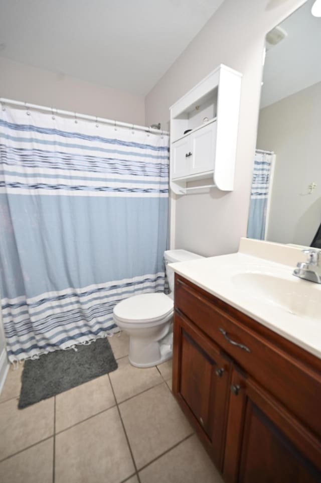 bathroom with toilet, a shower with curtain, tile patterned flooring, and vanity