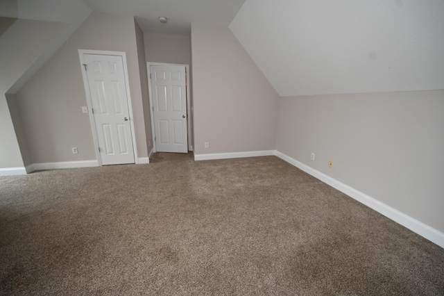bonus room with carpet floors, baseboards, and vaulted ceiling
