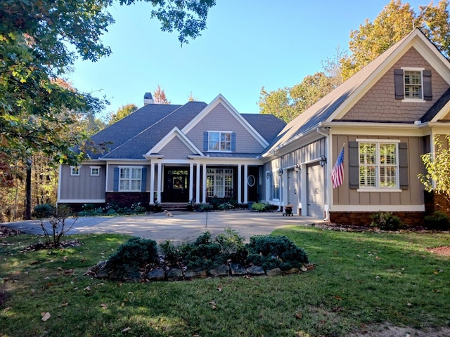 back of house with a lawn, a garage, a chimney, and concrete driveway