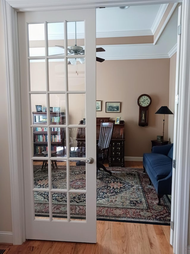 doorway featuring a ceiling fan, ornamental molding, and wood finished floors