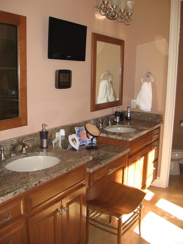 full bath featuring a sink, toilet, and double vanity