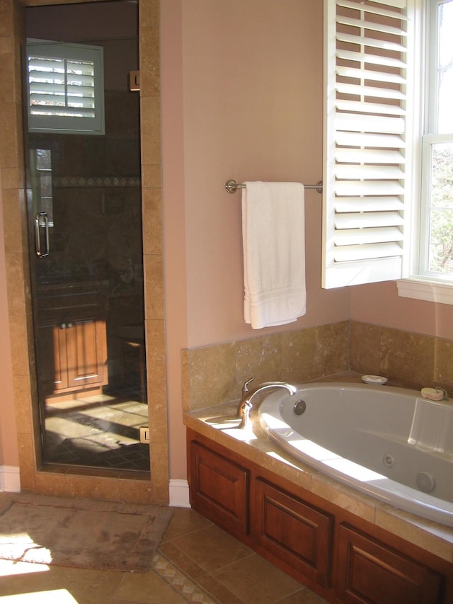 full bathroom with baseboards, tile patterned flooring, a stall shower, and a tub with jets