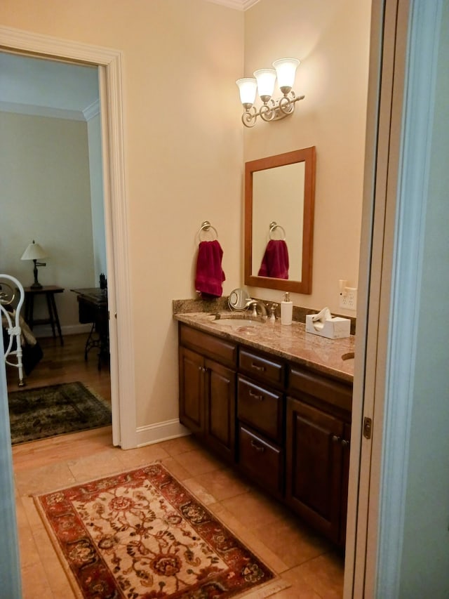 bathroom featuring baseboards, ornamental molding, and vanity