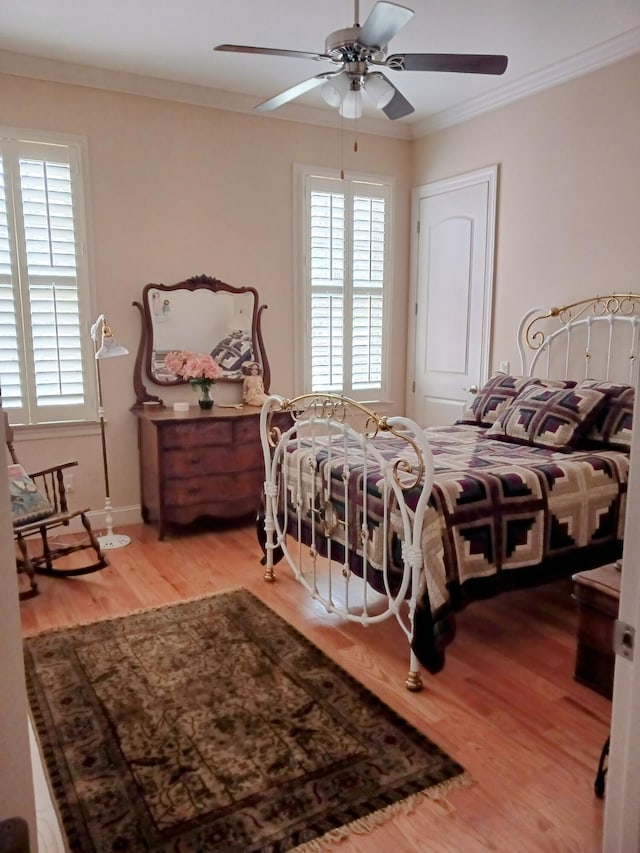 bedroom with crown molding, ceiling fan, and wood finished floors