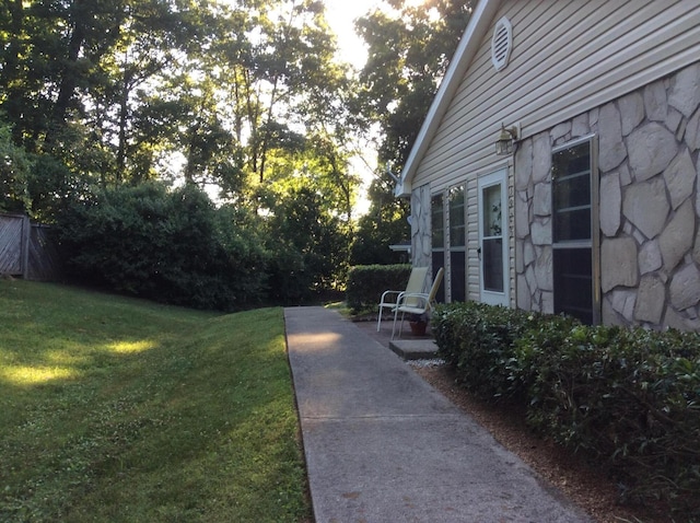 exterior space featuring a yard and stone siding