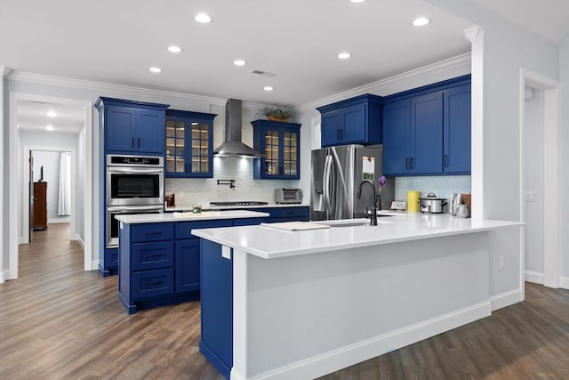 234 Reflection Dr, Dunlap, TN 37327 - kitchen featuring blue cabinetry, wall chimney range hood, stainless steel appliances, a peninsula, and ornamental molding