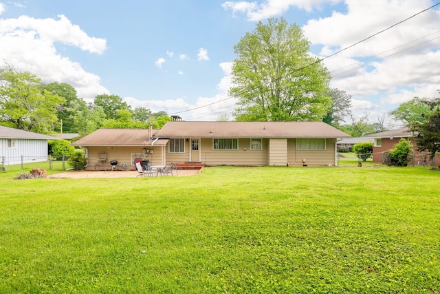 rear view of property with fence, a lawn, and a patio area